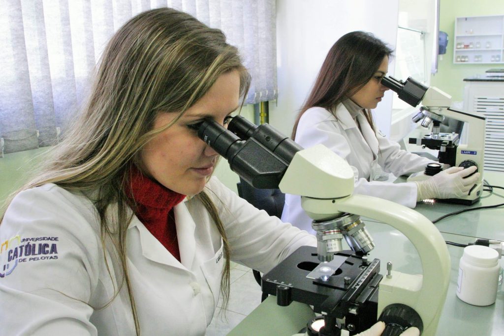 Guia do Estudante: estudantes de farmácia olham através de microscópio