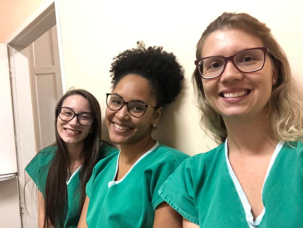 Intercâmbio nacional: estudante da Bahia com alunas da UCPel sorrindo, em plantão médico