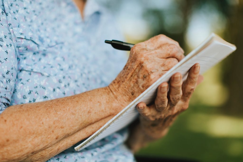 Benefícios estudar terceira idade: idosa escrevendo em caderno