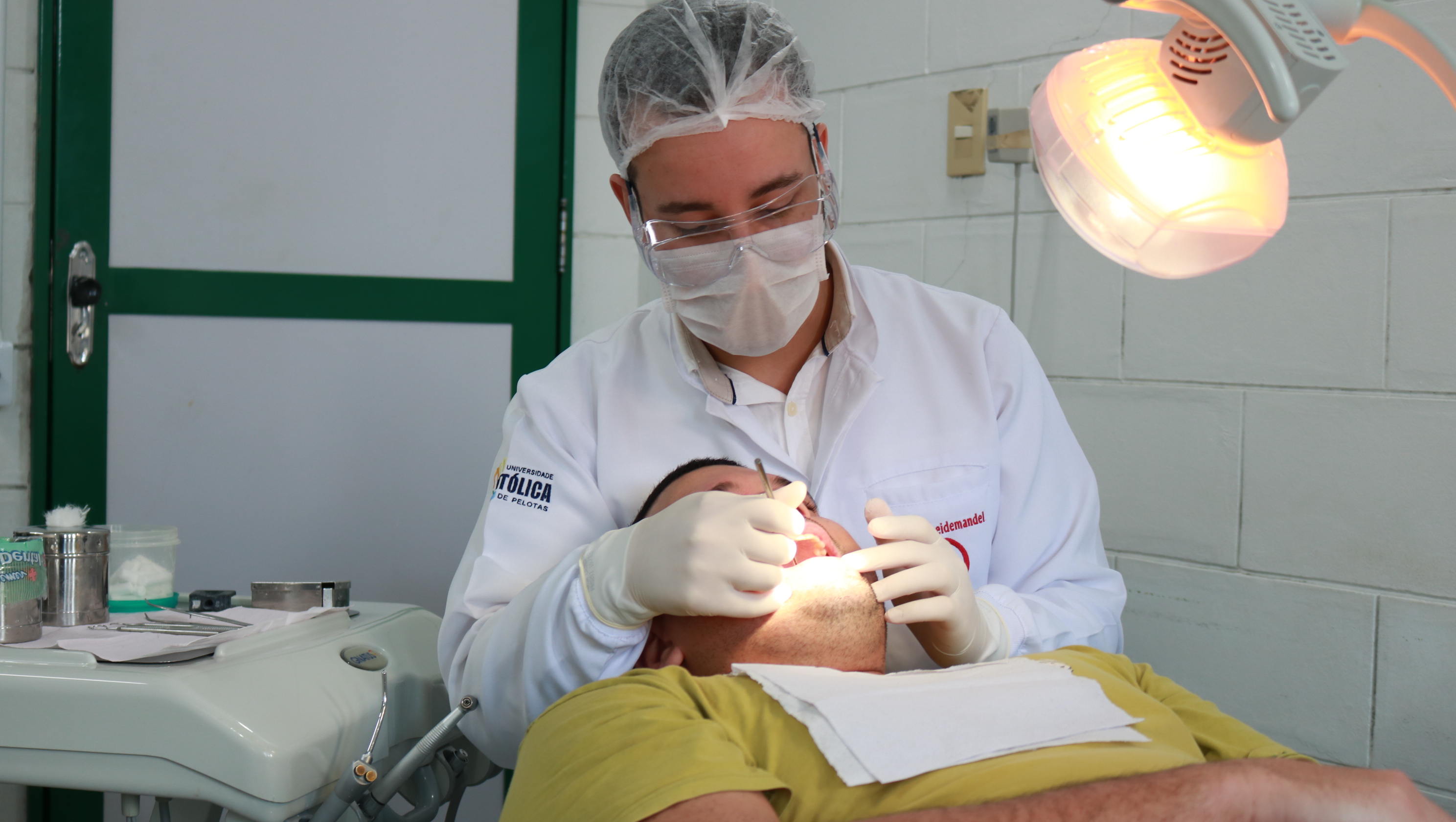 Acadêmico da Odontologia UCPel realizando atendimento a paciente
