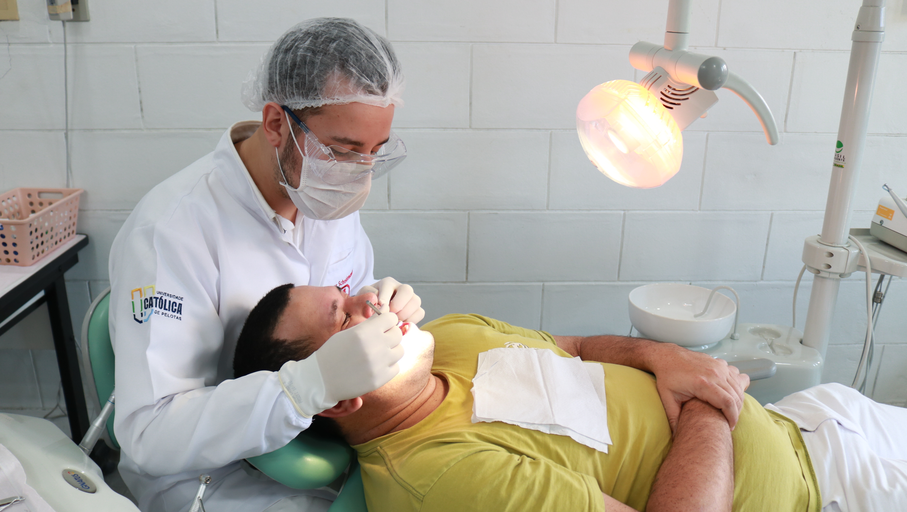 acadêmico da odontologia UCPel realizando atendimento a paciente